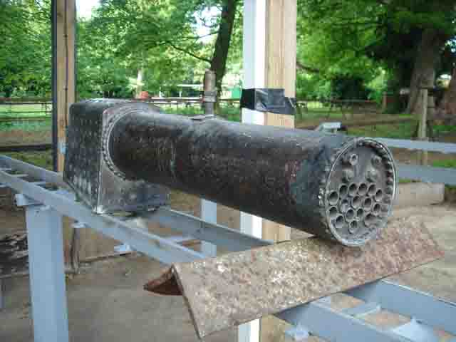 A model steam locomotive boiler propped up on a raised outdoor track